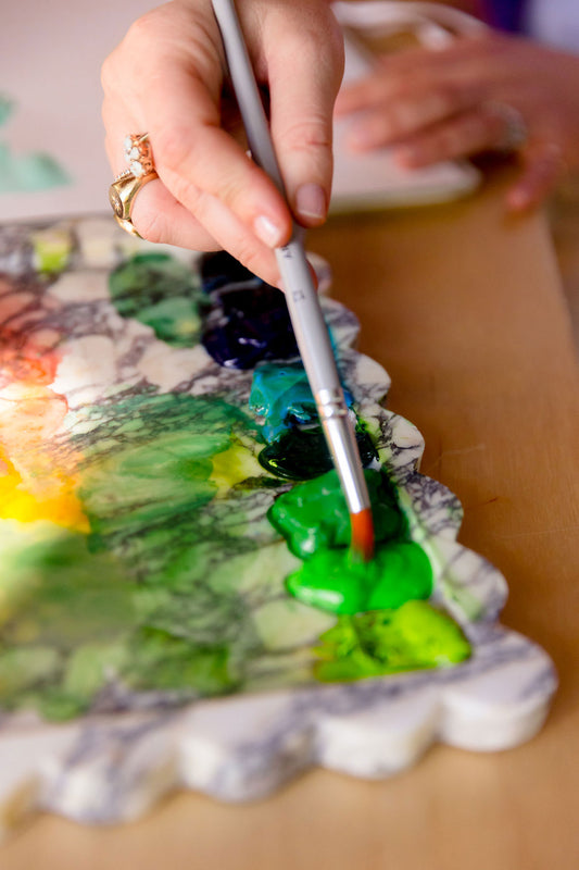 watercolor palette with brush and artist playing around with color mixing and selection for watercolor sketchbook art